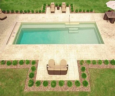 A backyard swimming pool with steps leading into the water, surrounded by a beige tiled deck, with two outdoor chairs facing the pool, and green grass with a flower bed and small bushes lining the area.