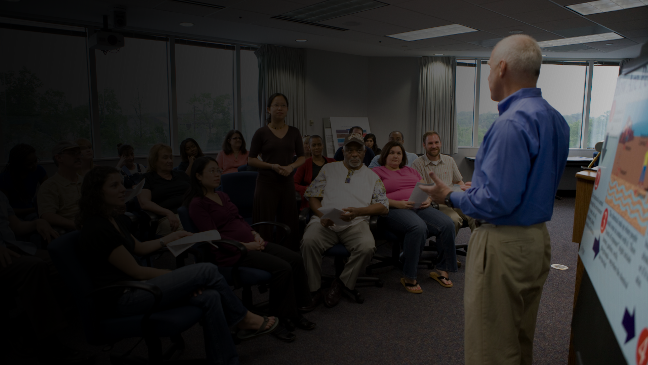 Man addresses room of people