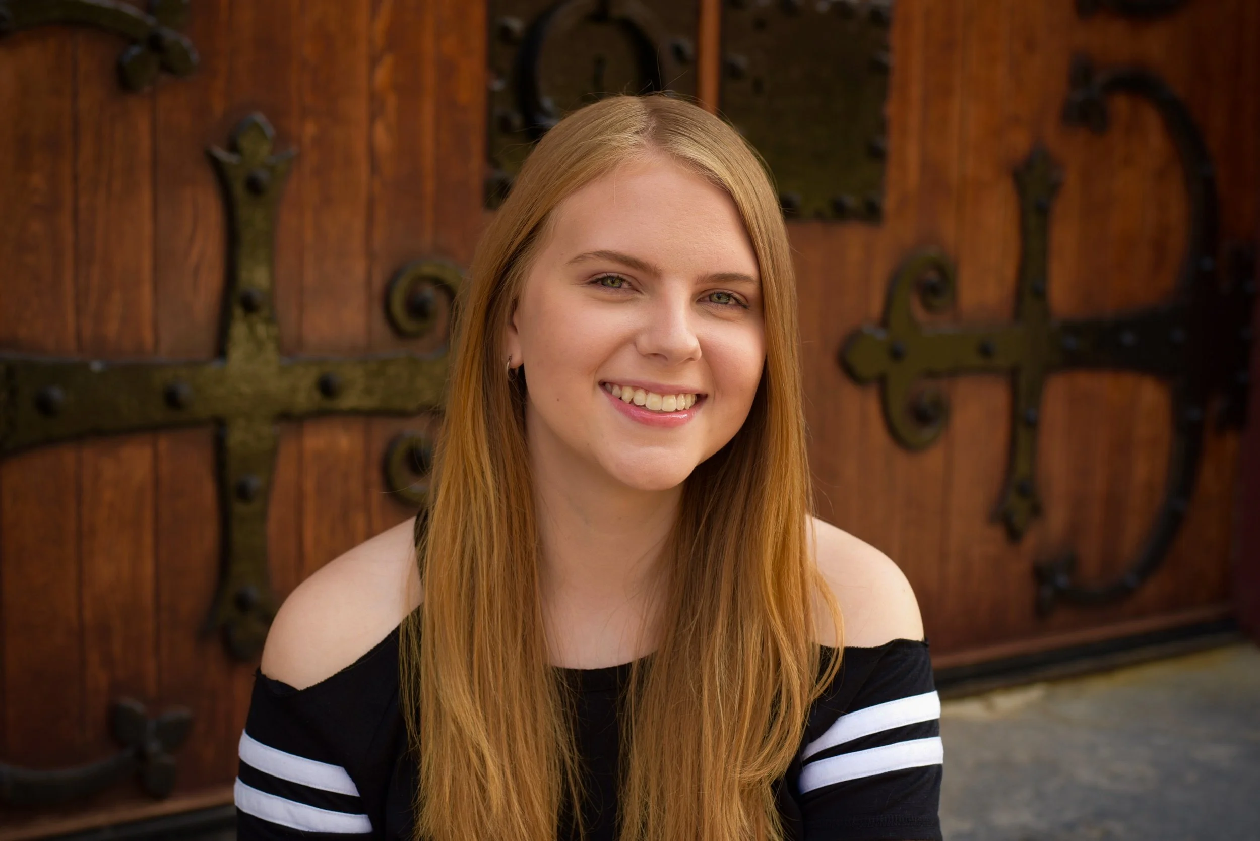 Portrait of a young woman with long blonde hair, smiling.