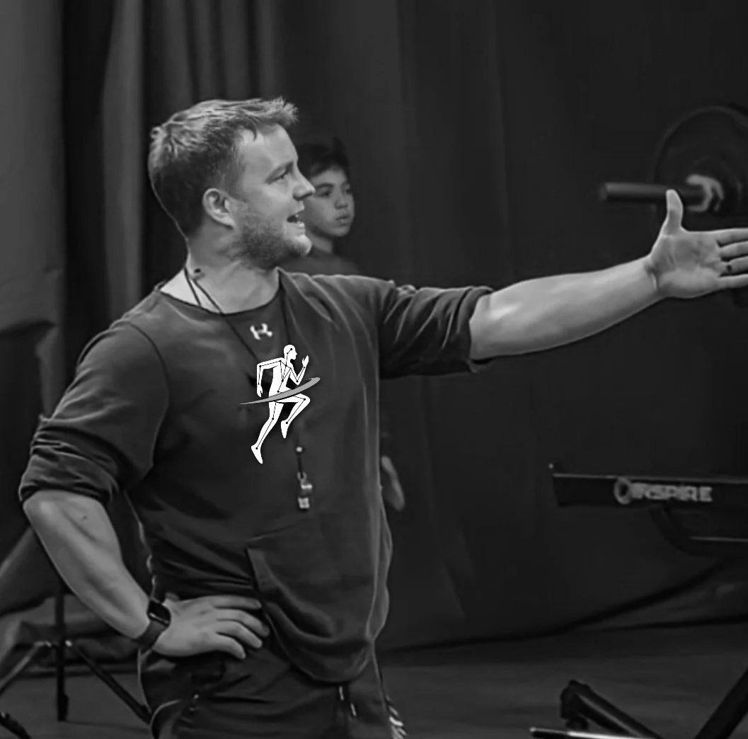 Coach giving instructions during a workout session with a young athlete in the background, black and white photo - Steve Gray Personal Trainer