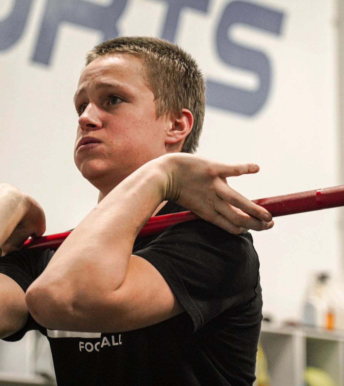 Young man lifting a barbell during weightlifting workout