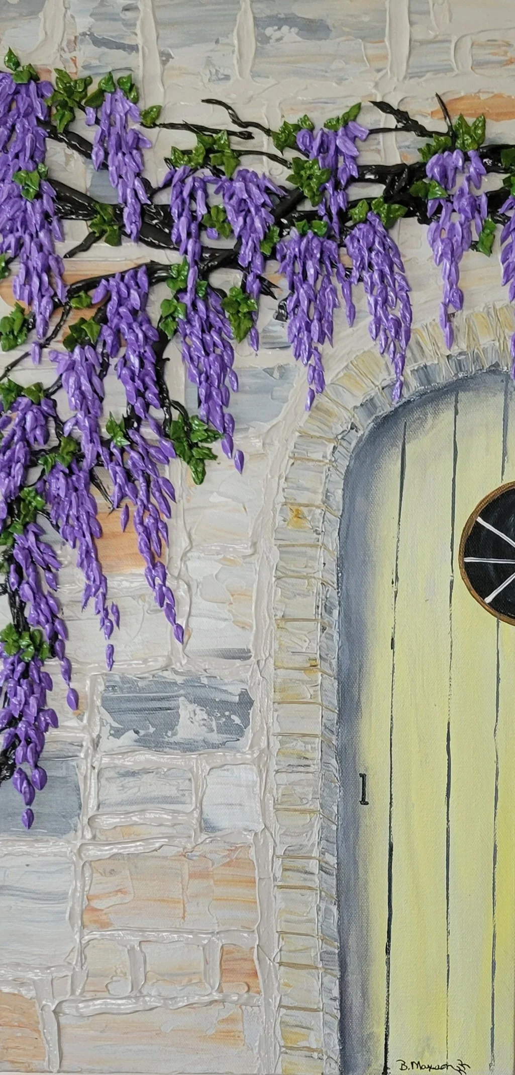 Wisteria drapes the doorway of a faded yellow wooden door clinging to the sturdy brick wall.