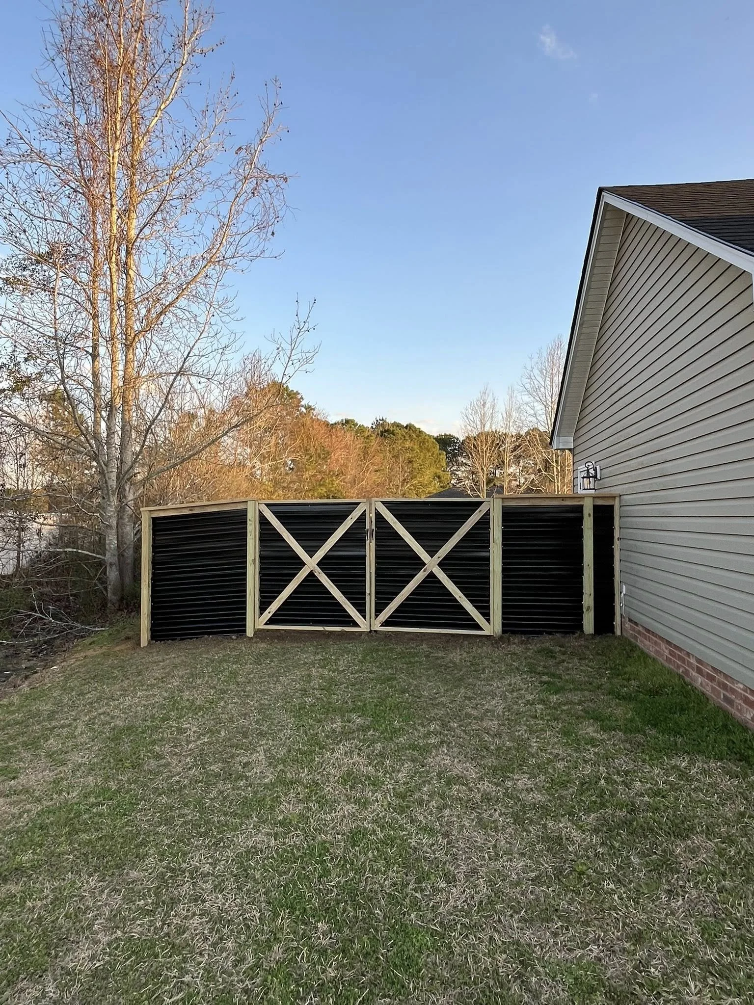 Custom Black corrugated metal privacy fence double gate built by Johnson Family Construction
