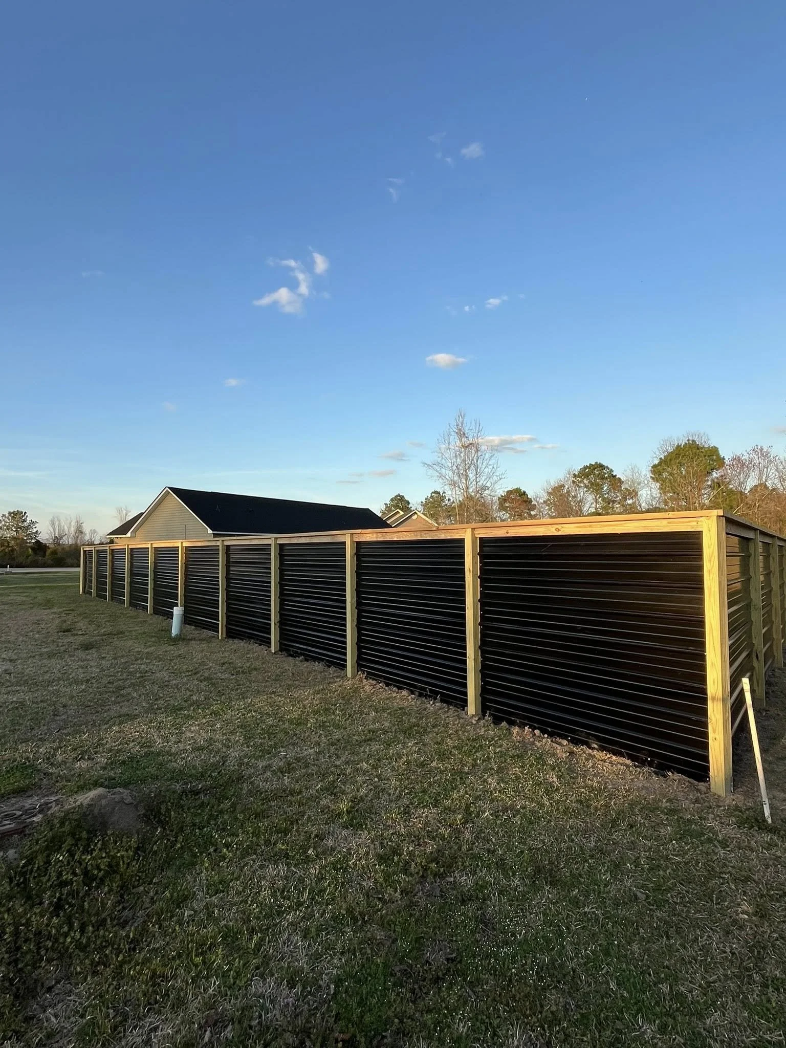Custom Black corrugated metal privacy fence built by Johnson Family Construction
