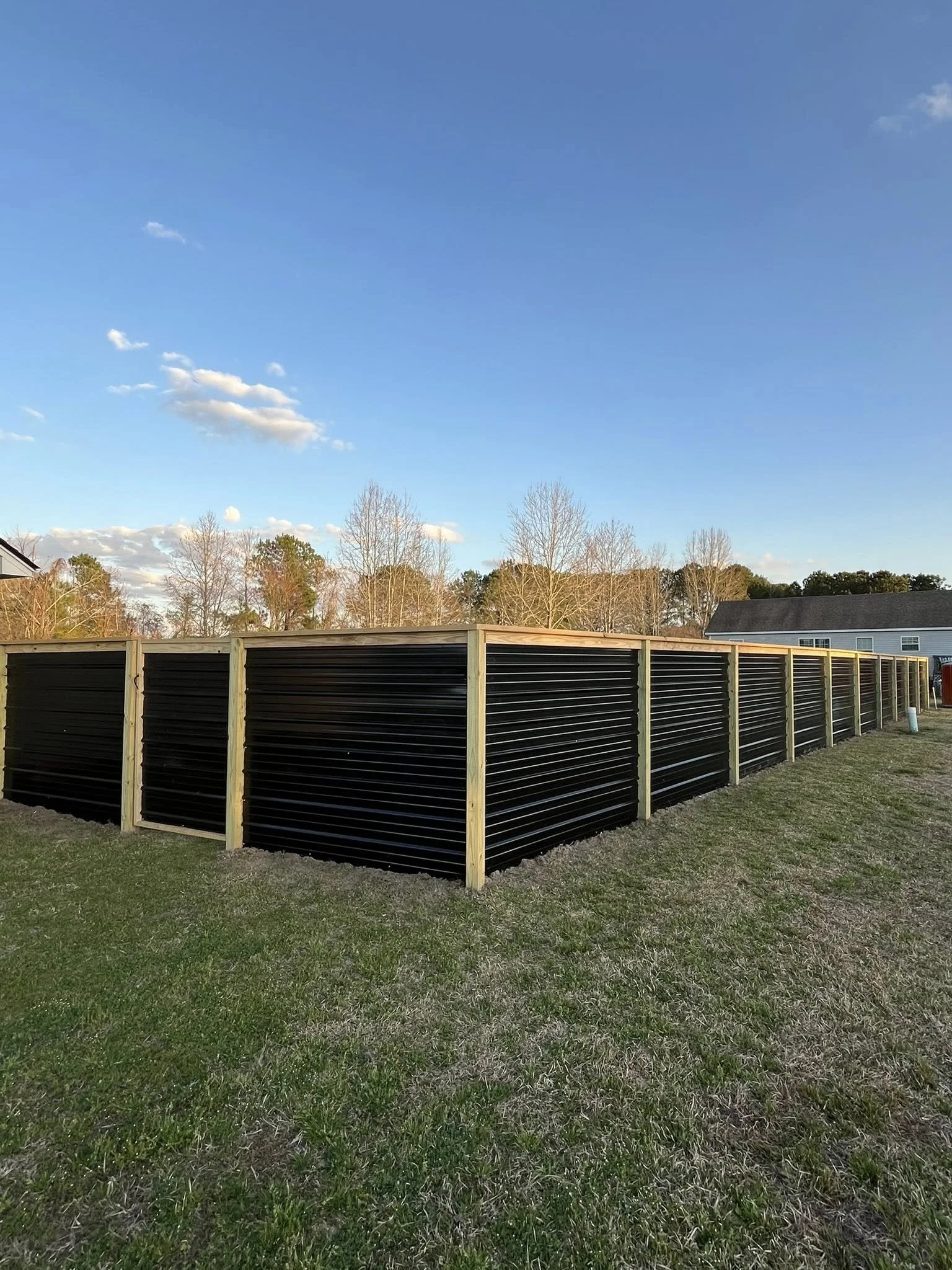 Custom Black corrugated metal privacy fence built by Johnson Family Construction 
