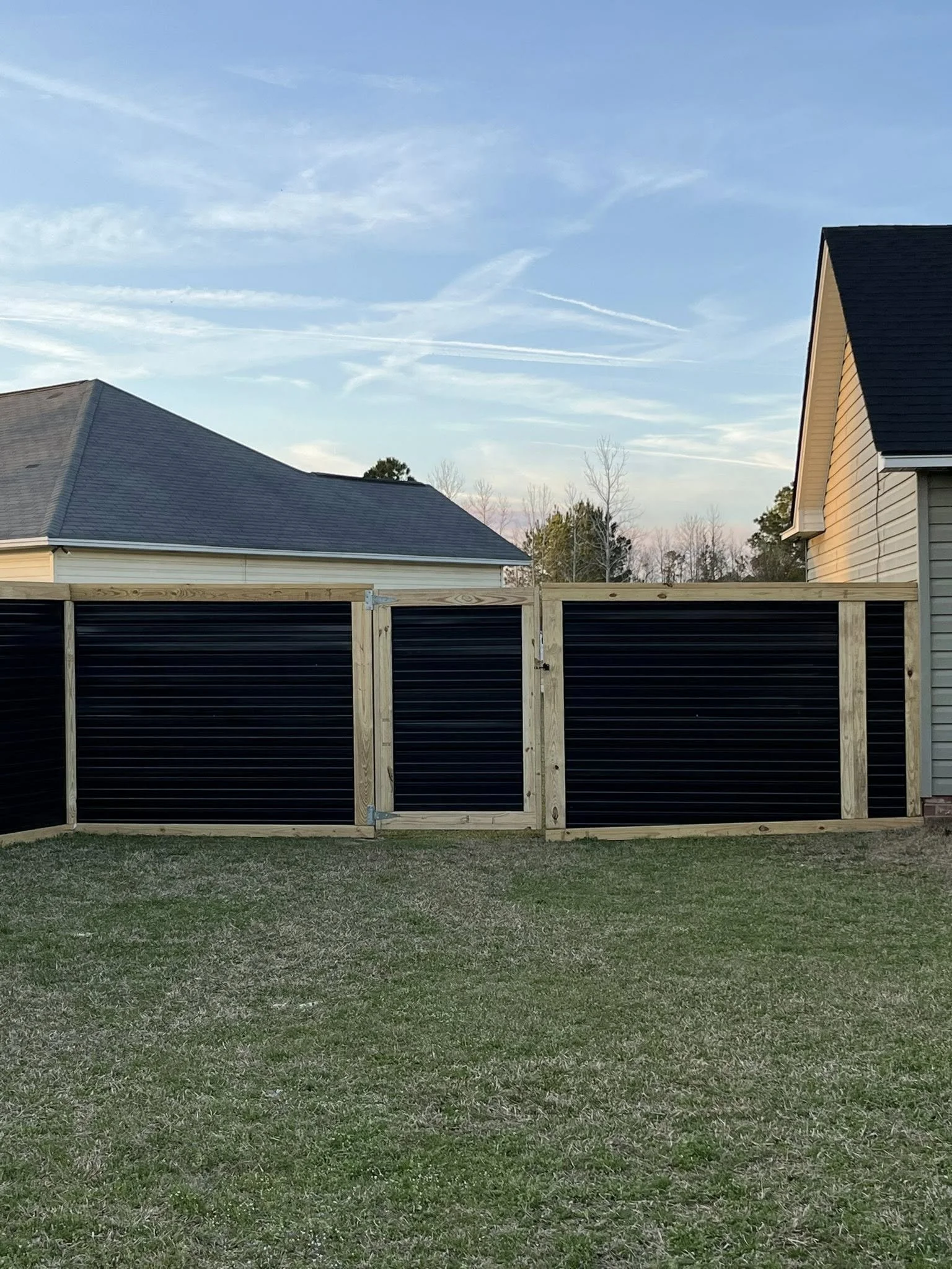 Custom Black corrugated metal privacy fence built by Johnson Family Construction