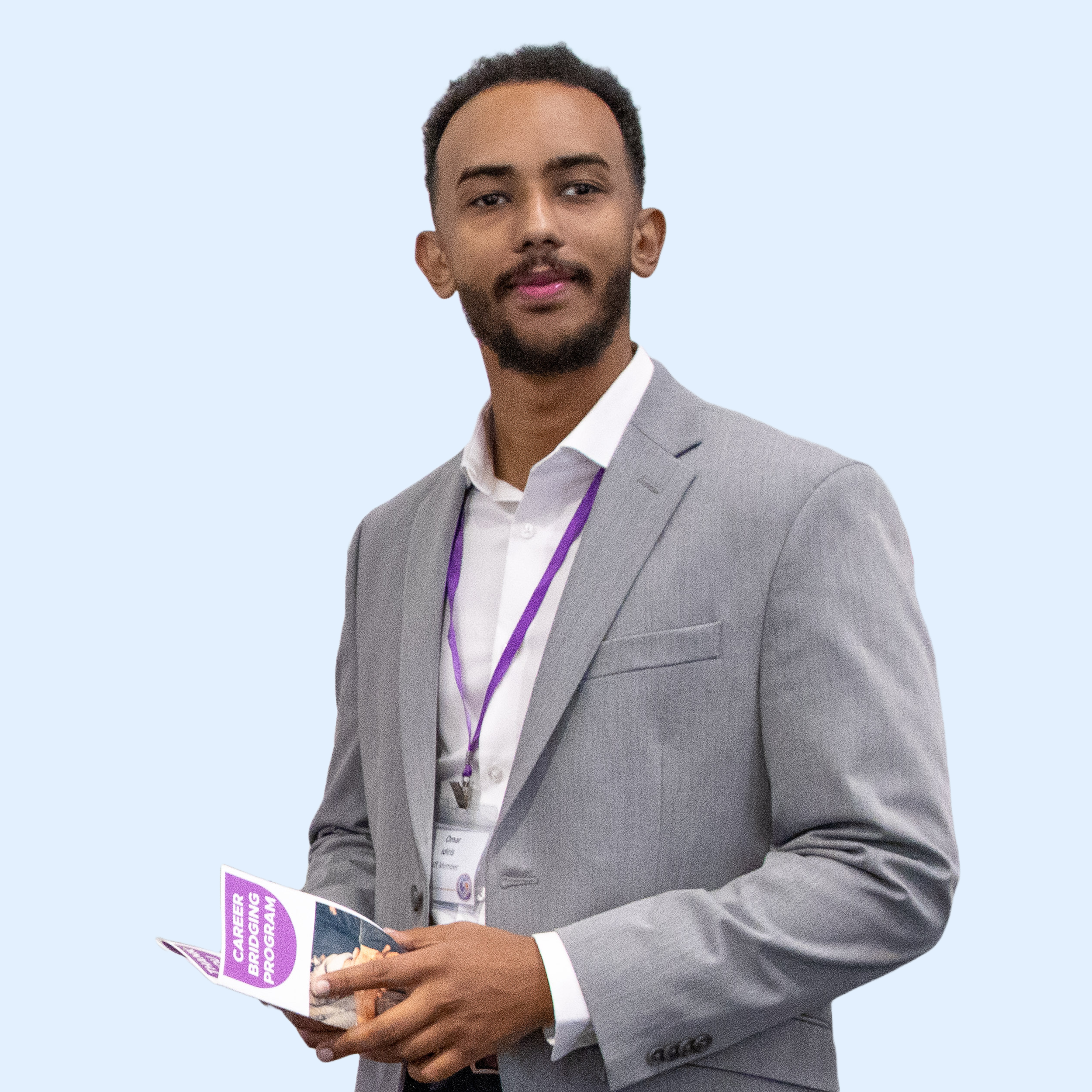 A man in a gray suit holding a brochure titled 'Career Bridging Program' in front of a light blue background.
