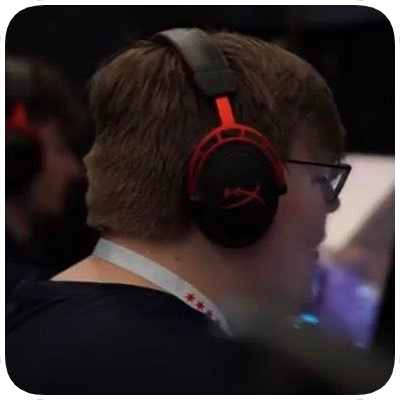 Young person wearing large black and red headset with glasses, focusing on a computer screen.
