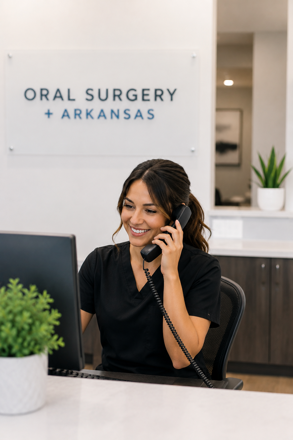 Receptionist answers calls at oral surgery clinic in Arkansas