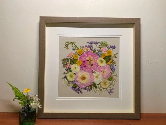 preserved flower bouquet in frame pinks yellows white light purple