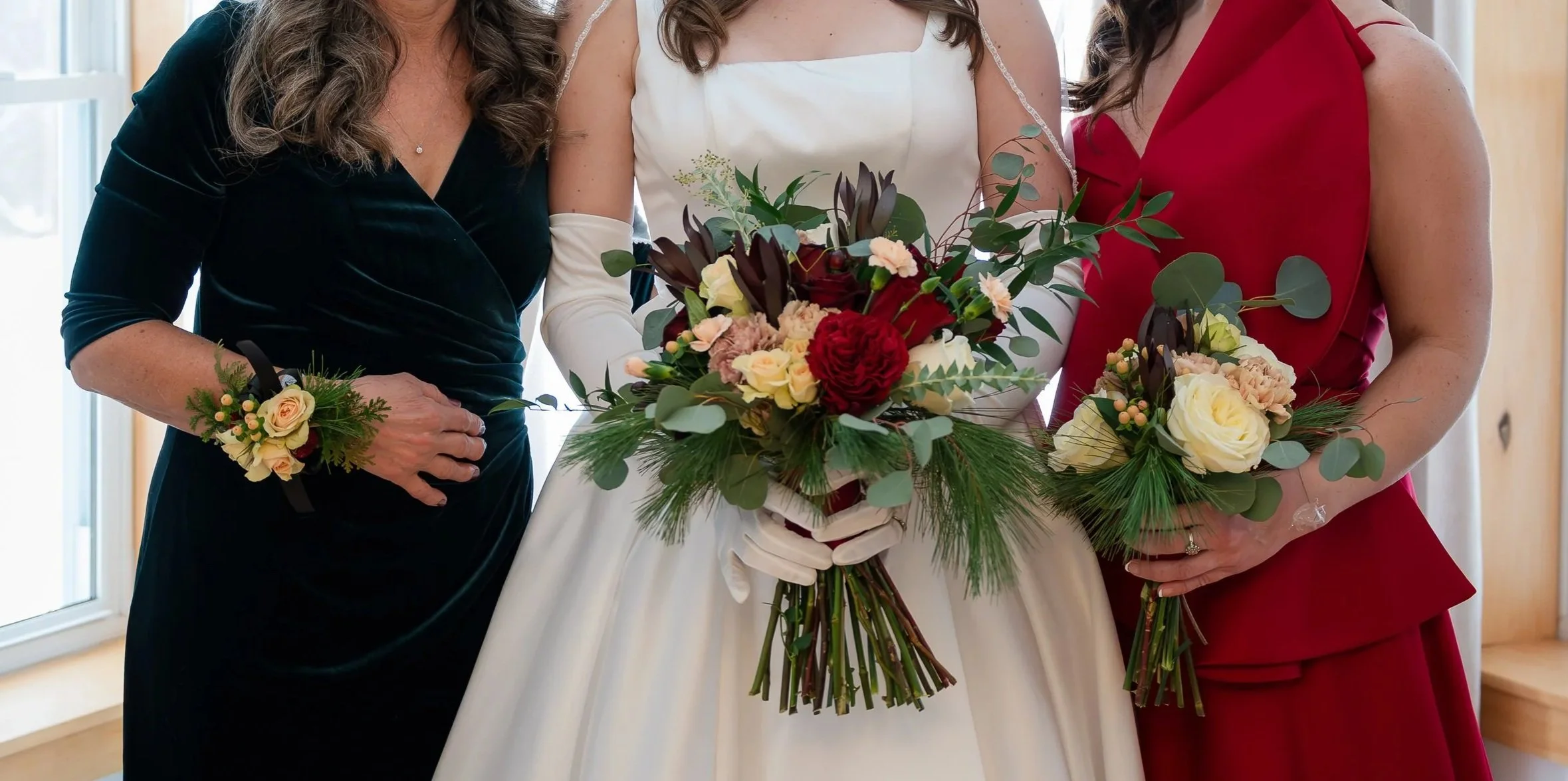 bride, mother of bride and bridesmaid holding bouquets and wearing corsage