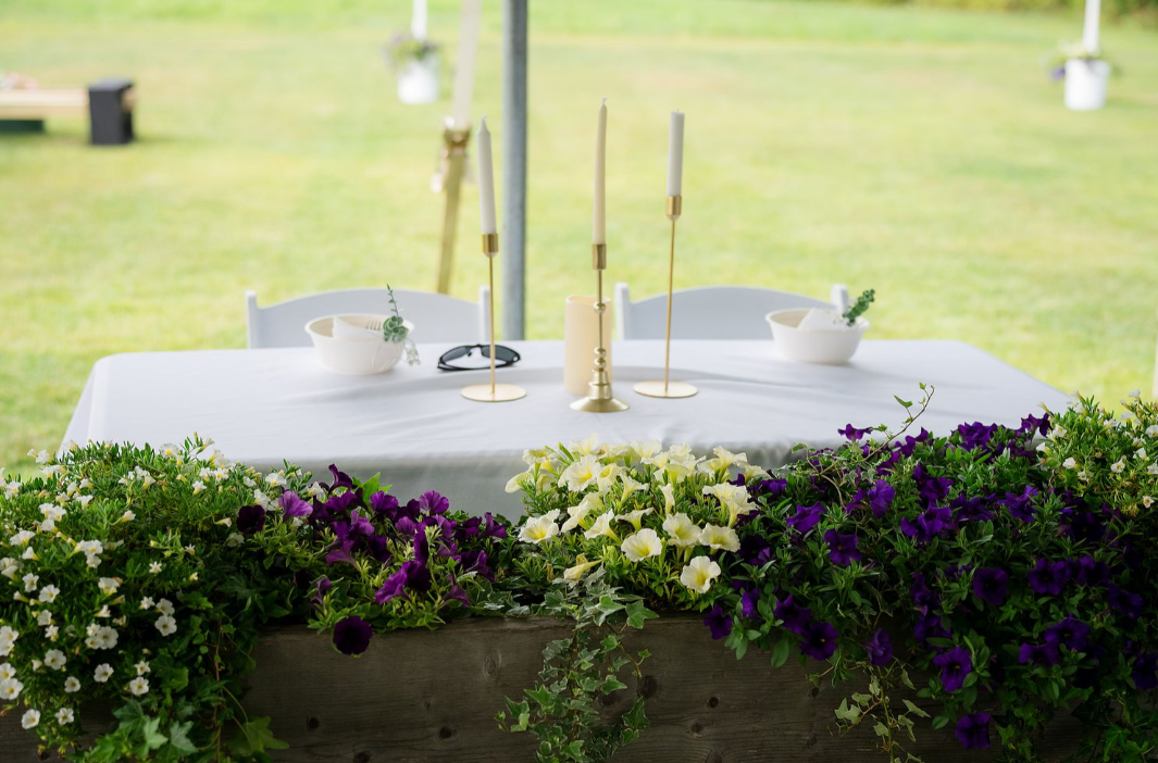 sweetheart table with white and purple planted flowers