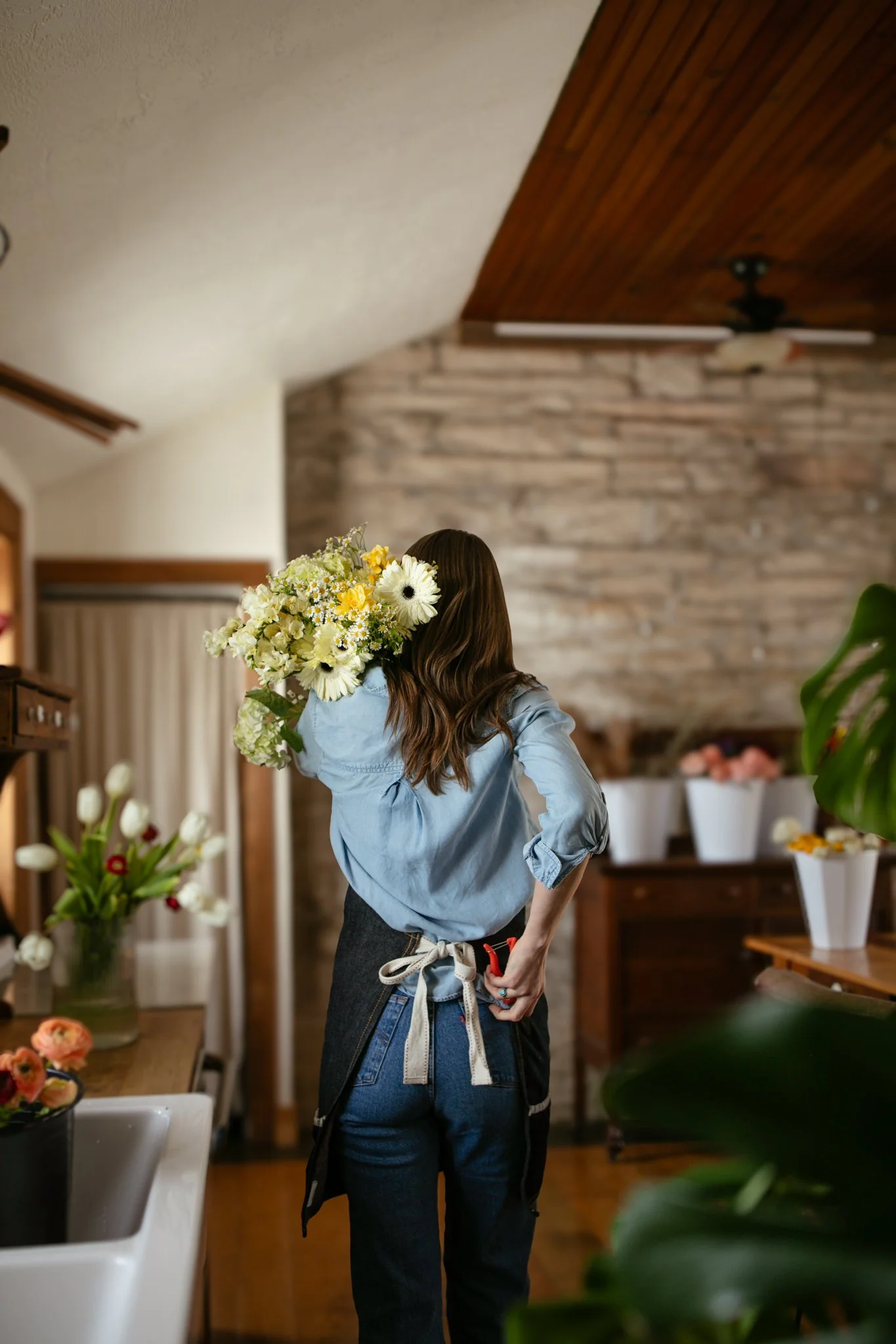 florist carrying flowers on shoulder with clippers in pocket