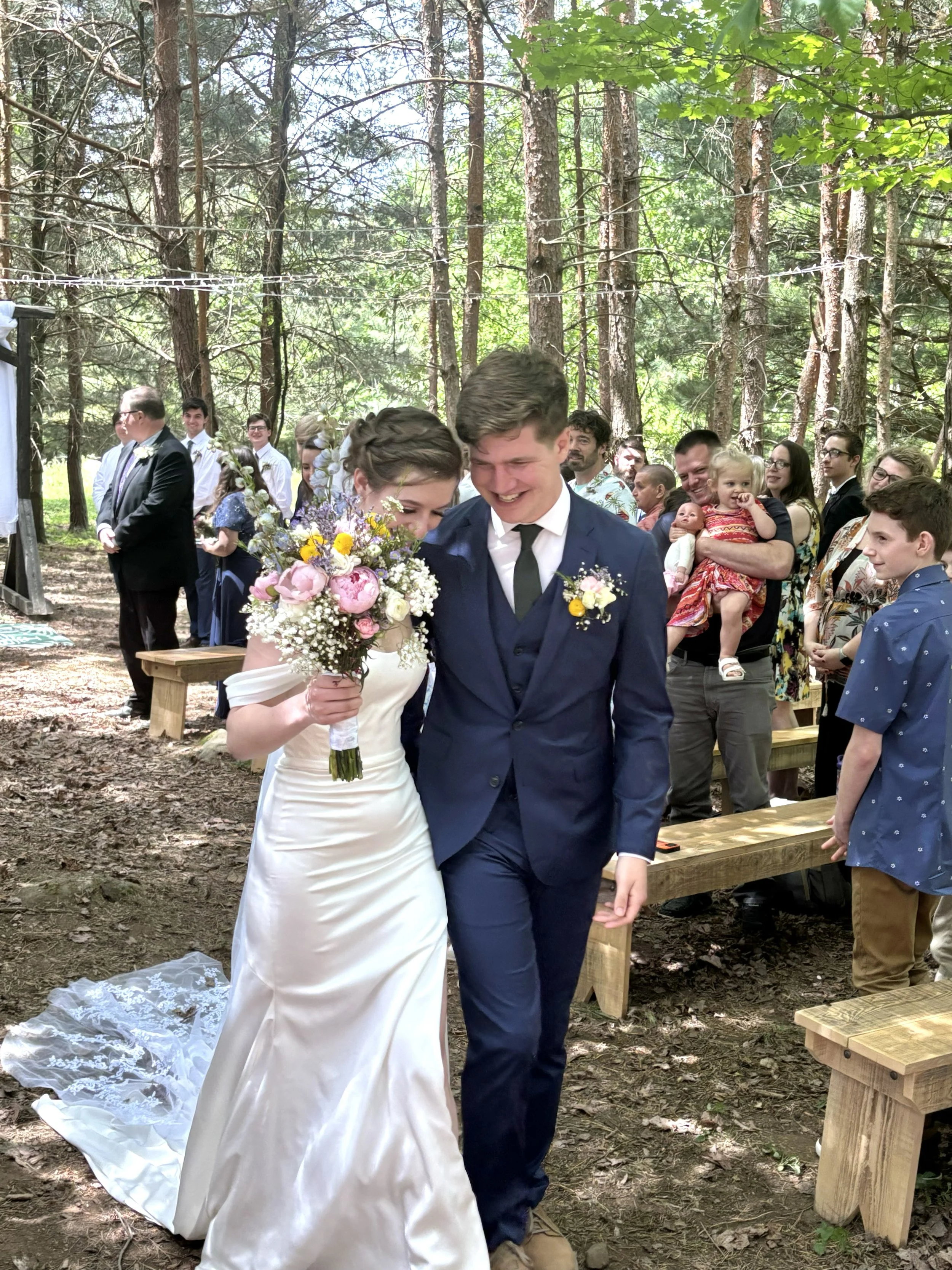bride and groom exit with spring color bouquet