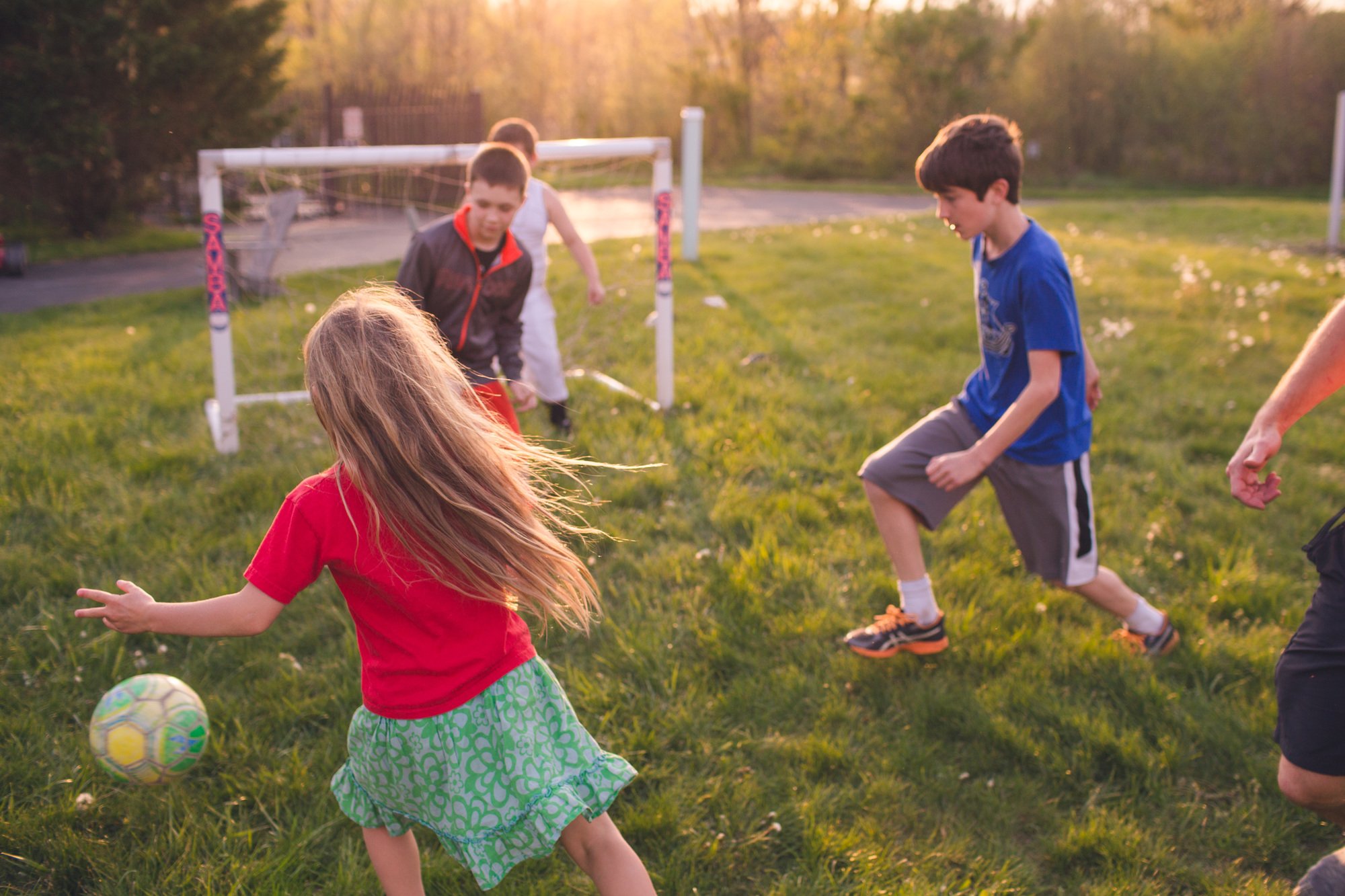 Several children in action playing a casual game of soccer.