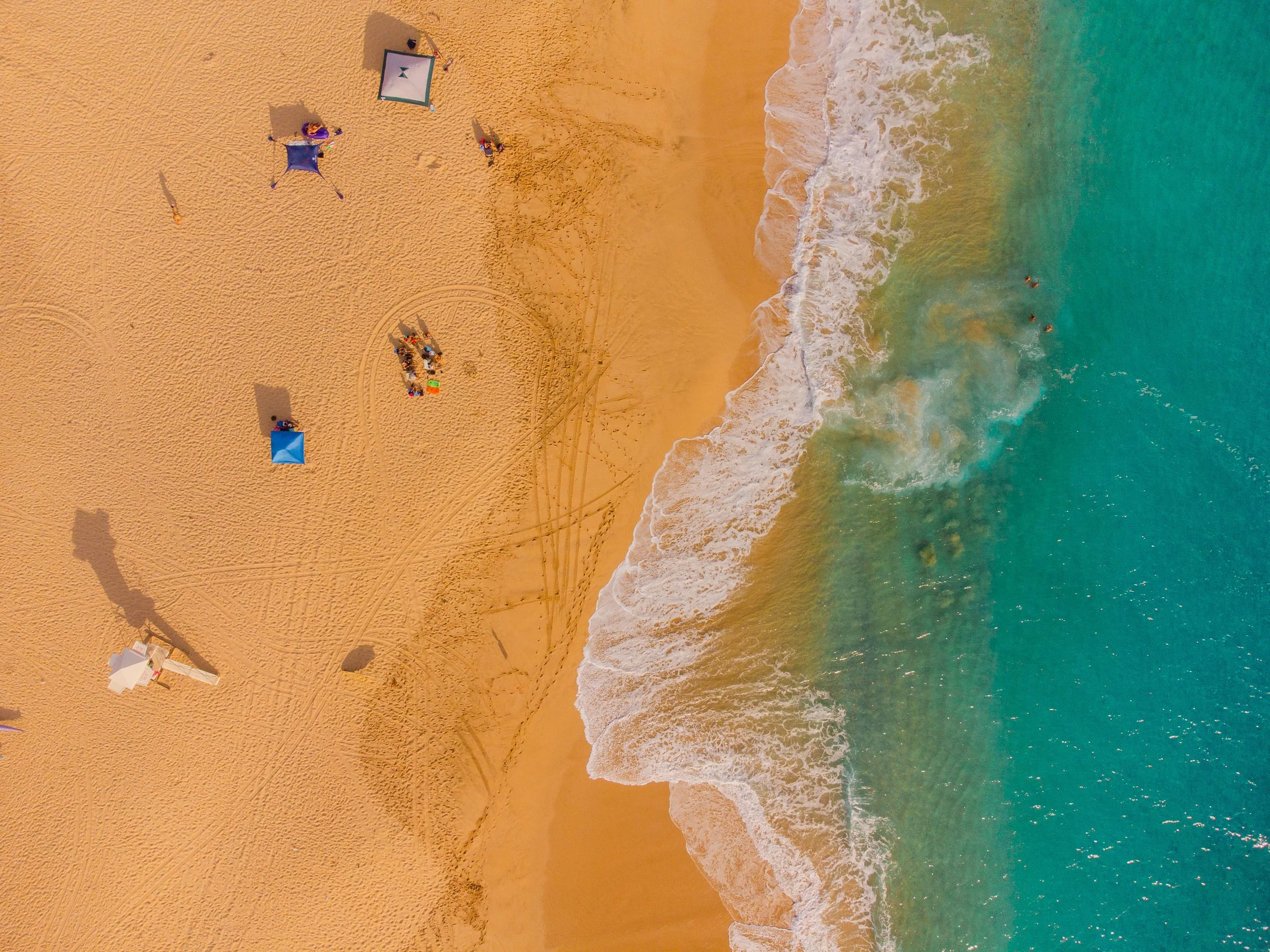 Aerial drone portrait of couple on an Oahu Hawaii beach at sunset.
