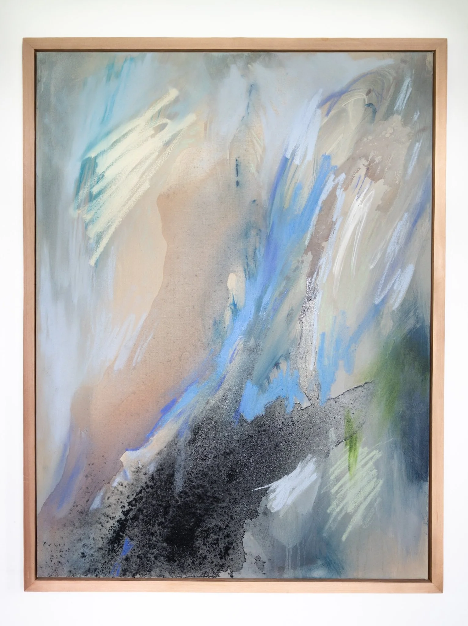 An abstract painting with swirling shades of blue, white, beige, black, and hints of green within a wooden frame.