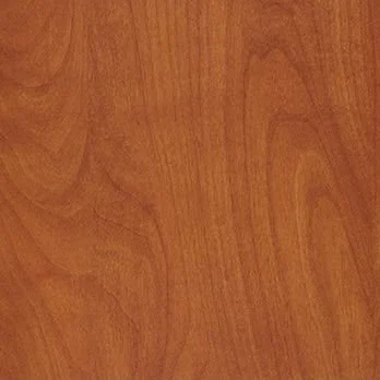 A close-up of a wooden surface, likely a tabletop or flooring, with a natural finish and visible wood grain.