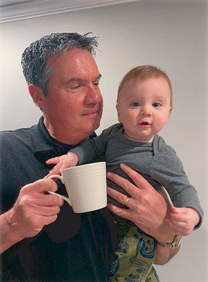 Image of donor holding coffee mug and grandbaby