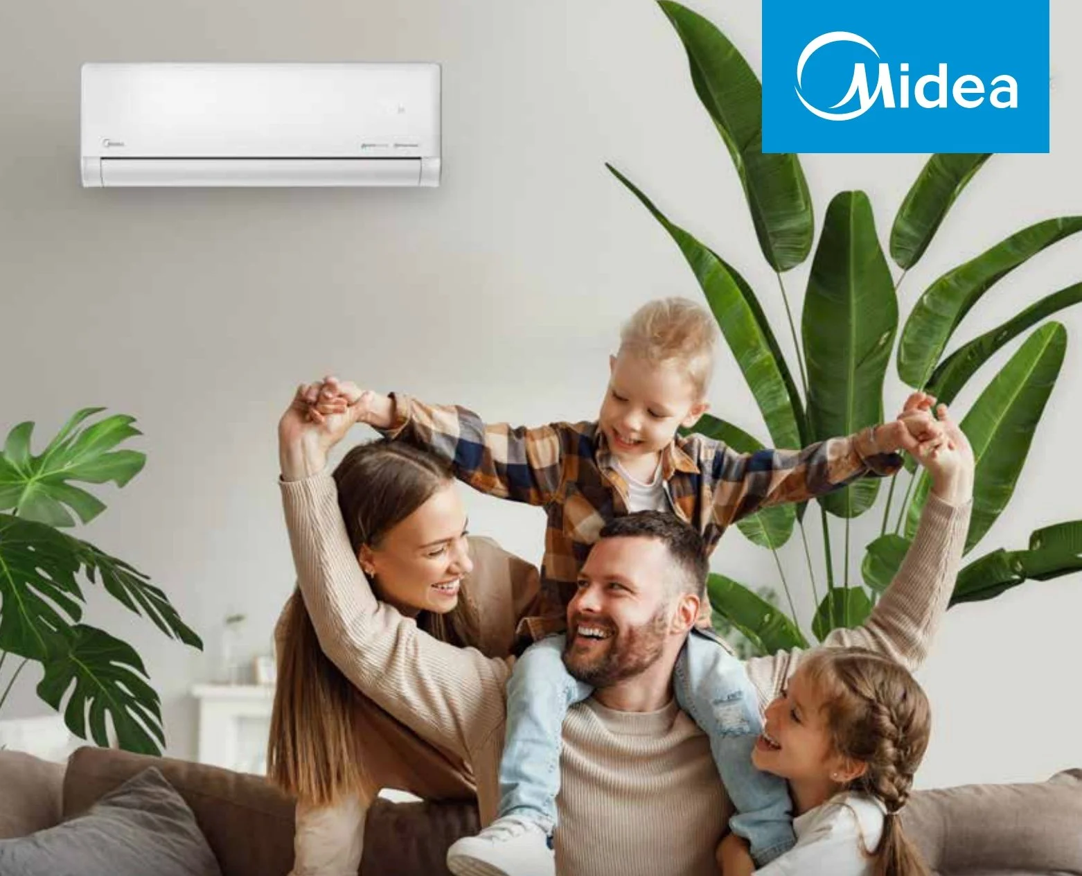 Una famiglia felice che si diverte in salotto con un condizionatore Midea visibile sulla parete.