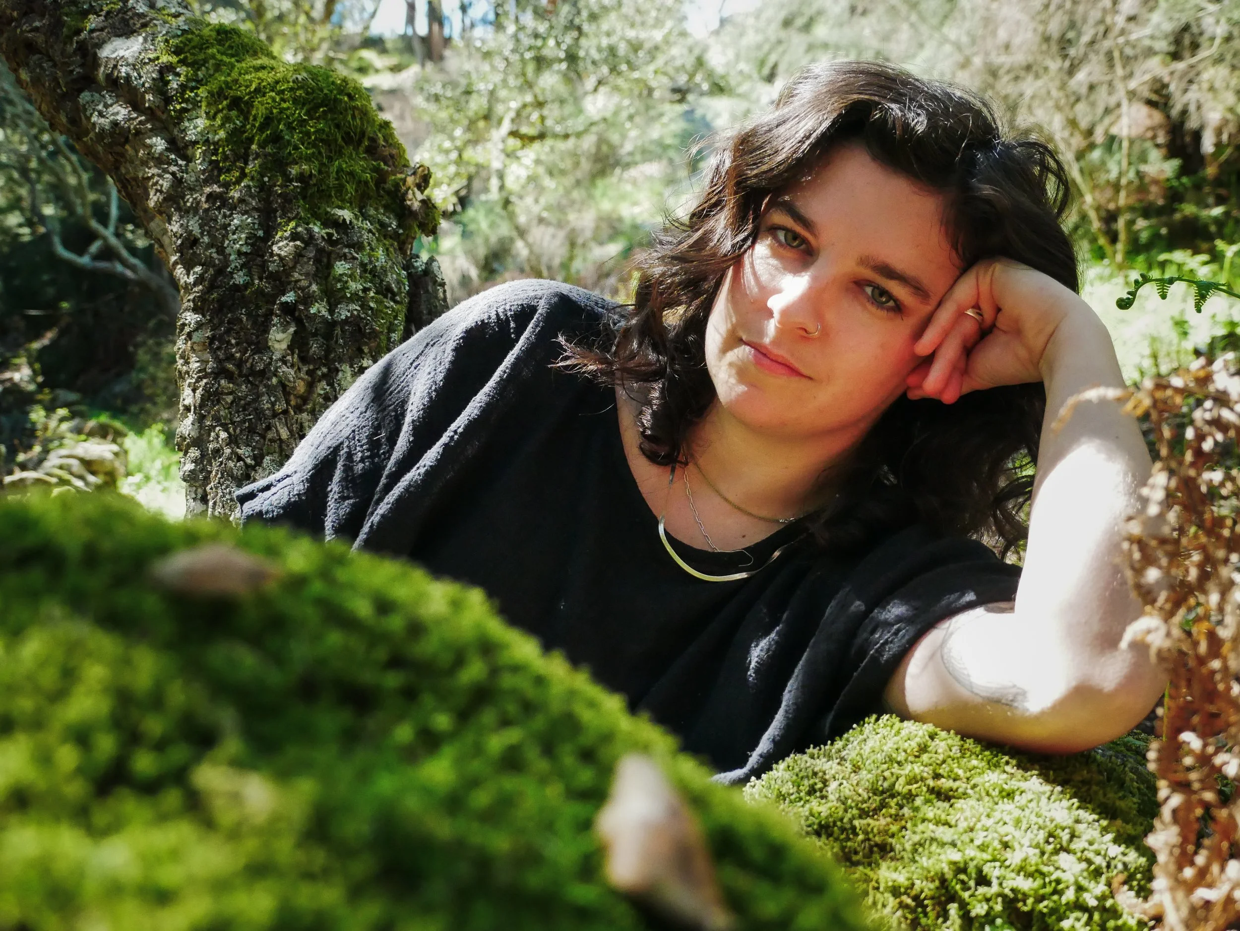 A somatic therapist in maine laying in nature.