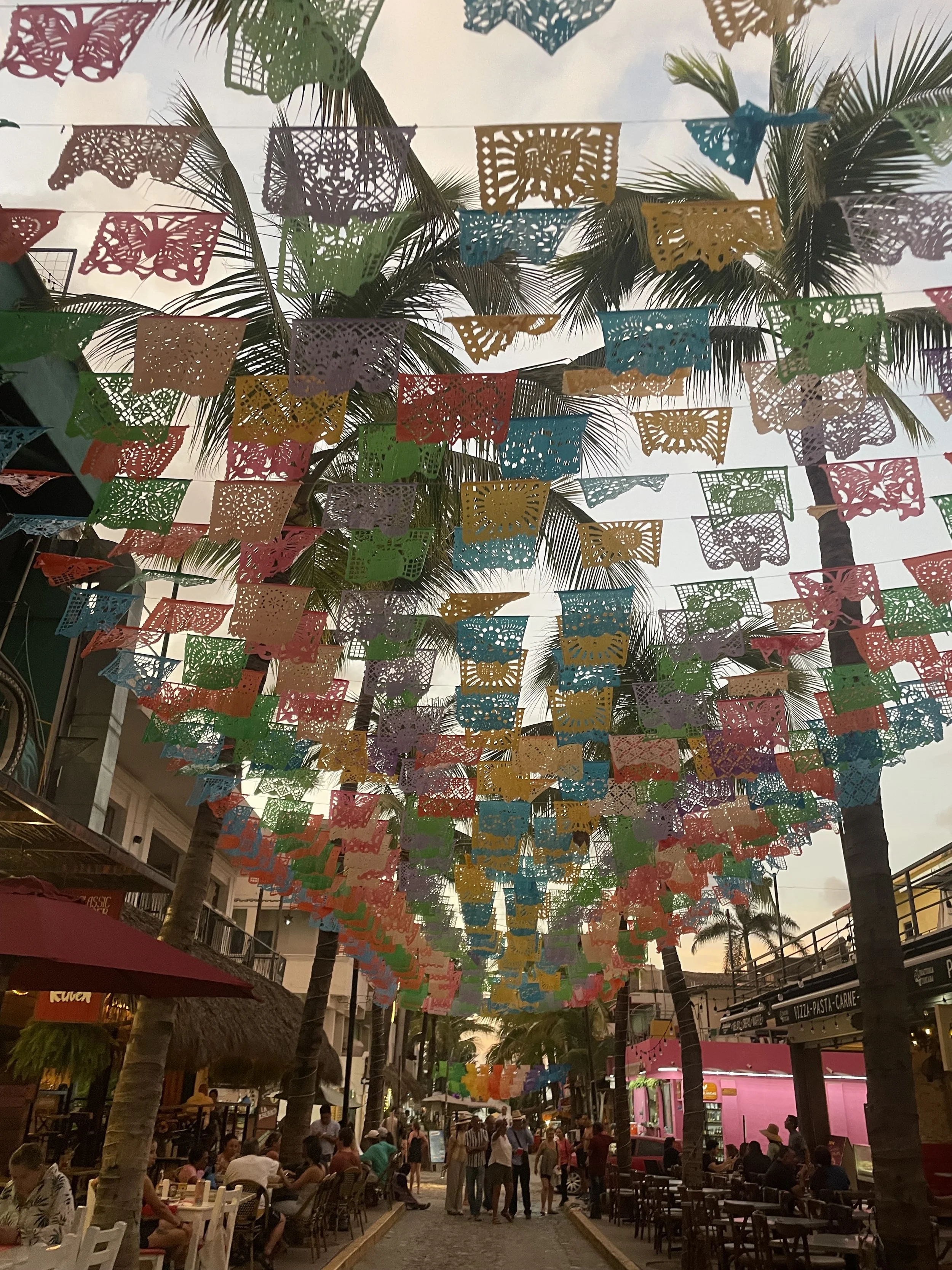 Colorful flags fly on streams in a Mexican city.