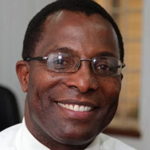 Close-up of a smiling man wearing glasses and a white shirt.