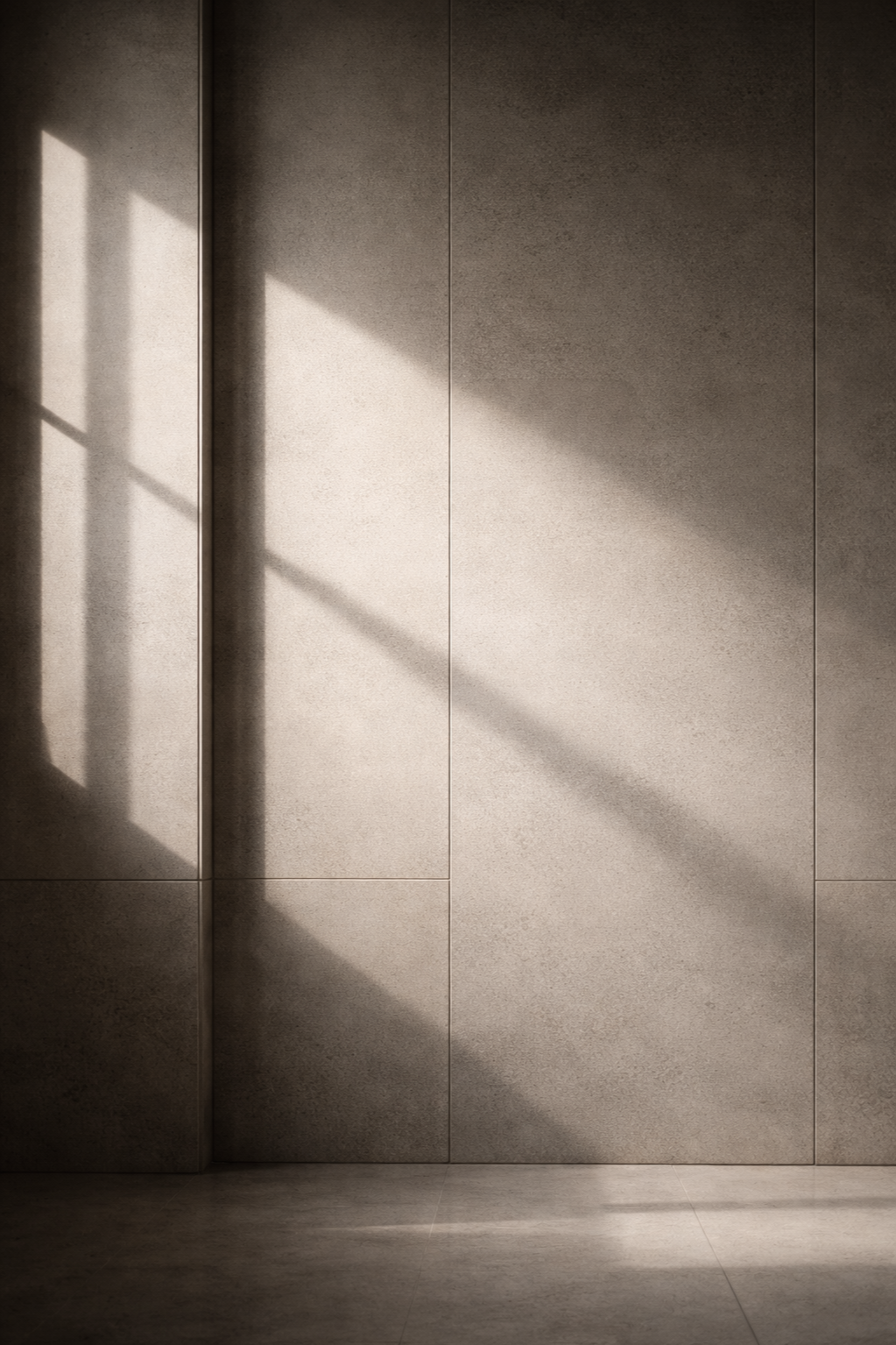 Sunlight creating shadows on a beige tiled wall.