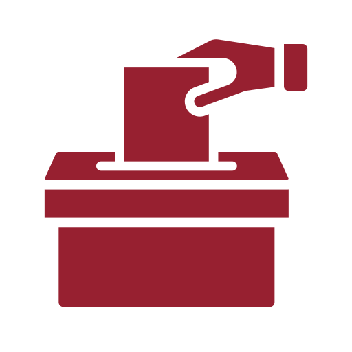 A voting ballot being inserted into a ballot box.