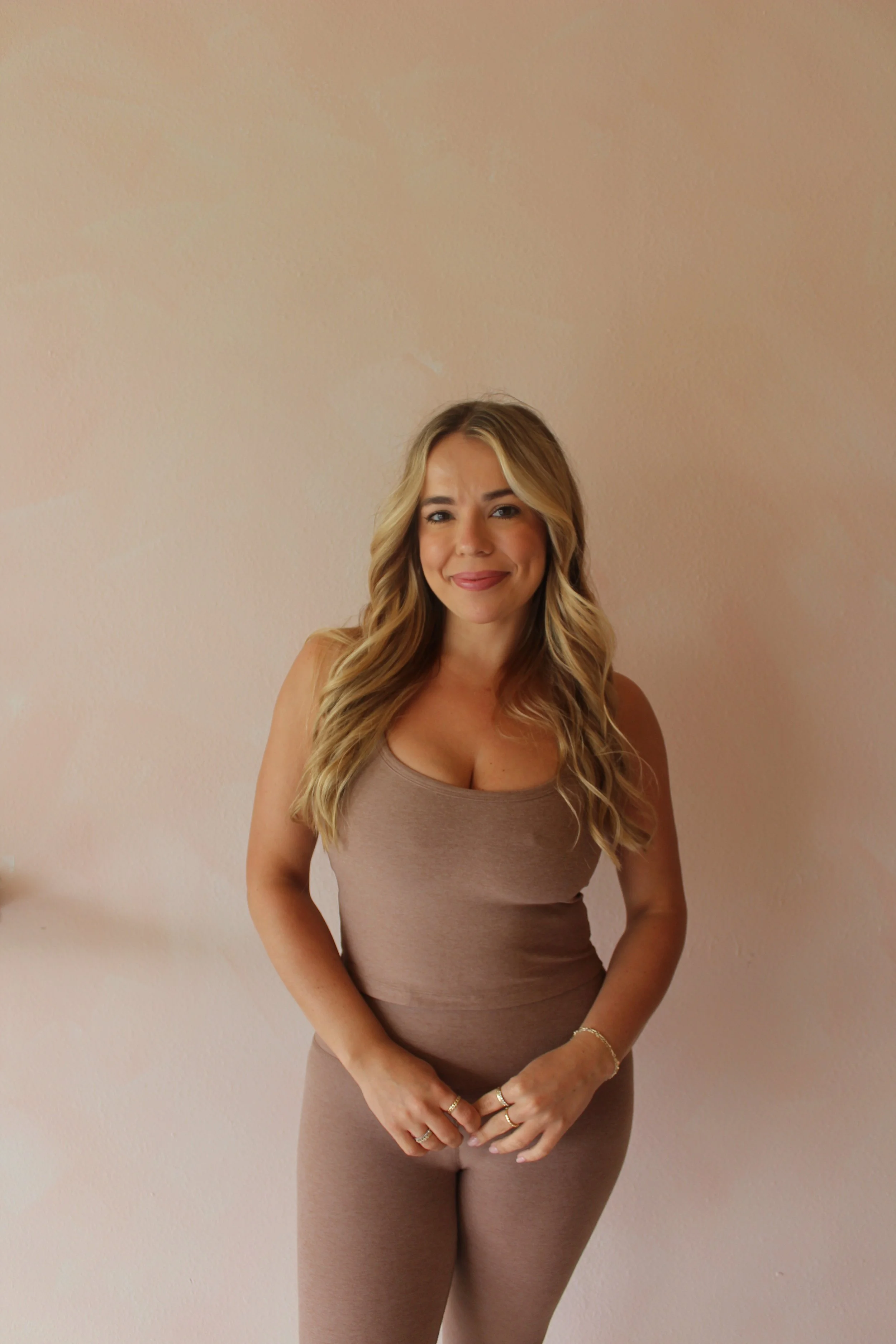 Pilates instructor standing in a neutral athletic outfit, smiling, at Third Space Studios in Houston