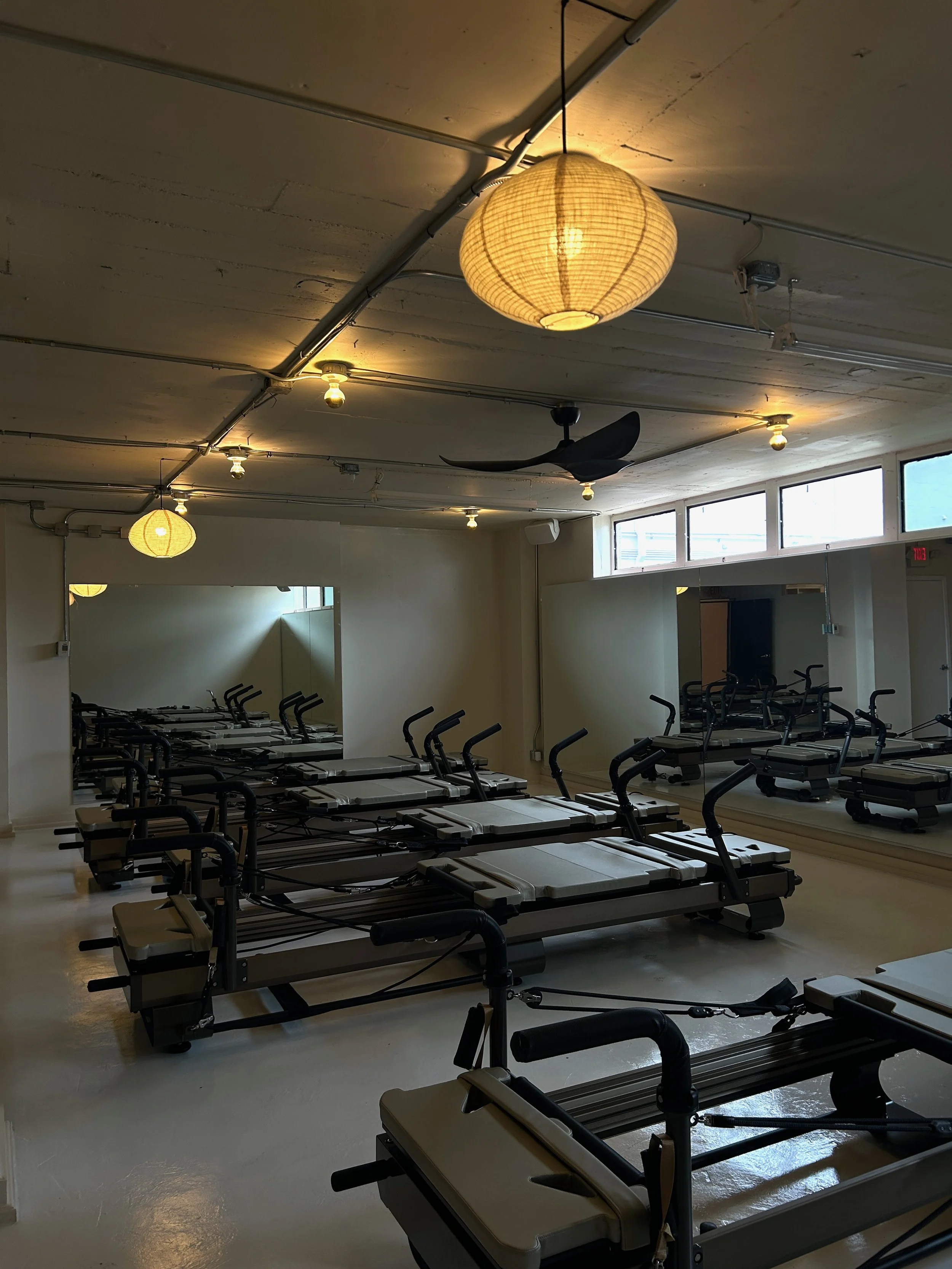 Calm reformer Pilates studio at Third Space Studios in Houston with multiple machines and soft lighting