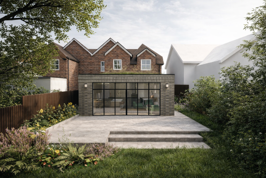 Backyard view with a modern glass extension, concrete patio, and surrounding greenery, with traditional brick houses in the background.