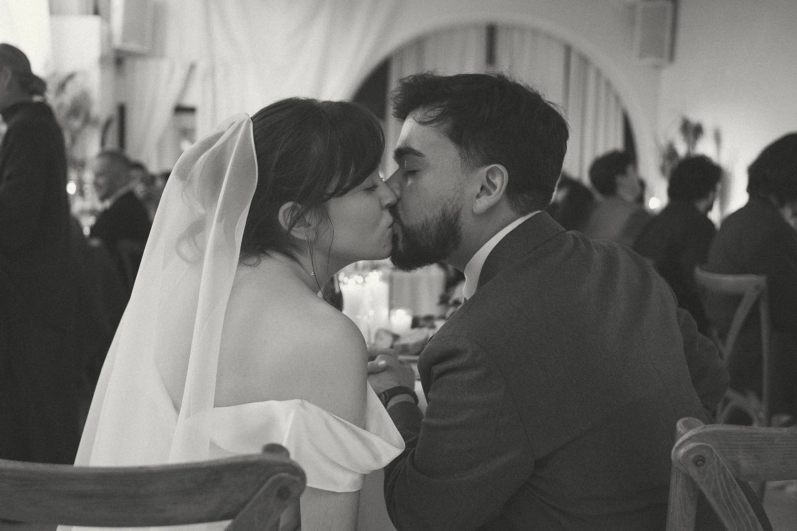 Black and white photo of a bride and groom kissing at their wedding reception. marigolds florals nyc florist wedding florals atmosfera wedding