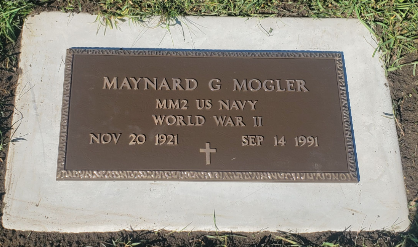 Gravestone with the name Maynard G Mogler, indicating service in the US Navy during WWII, with birth date November 20, 1921, and death date September 14, 1991, featuring a cross symbol.