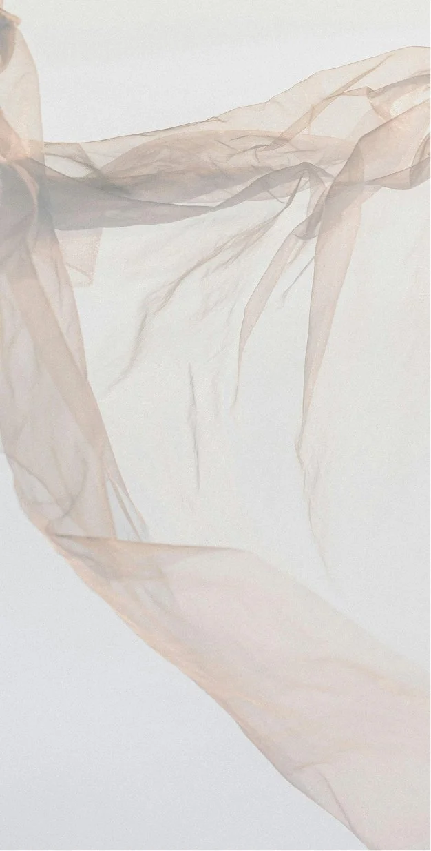Soft, sheer, beige fabric flowing against a white background.