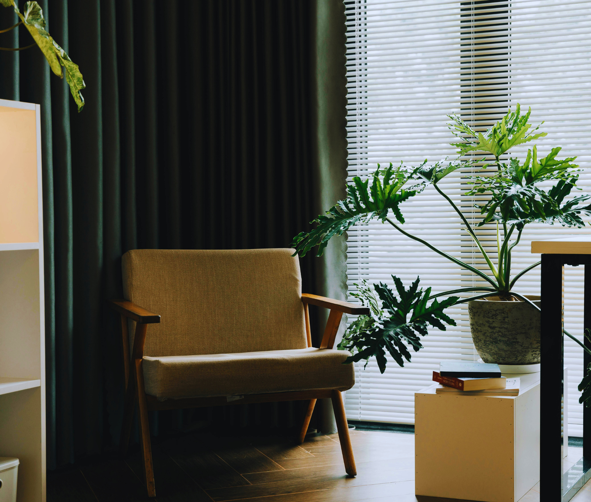 Cozy therapy office with an armchair, large houseplant, and laptop on a desk, representing the virtual therapy environment at Say More Therapy in Maryland