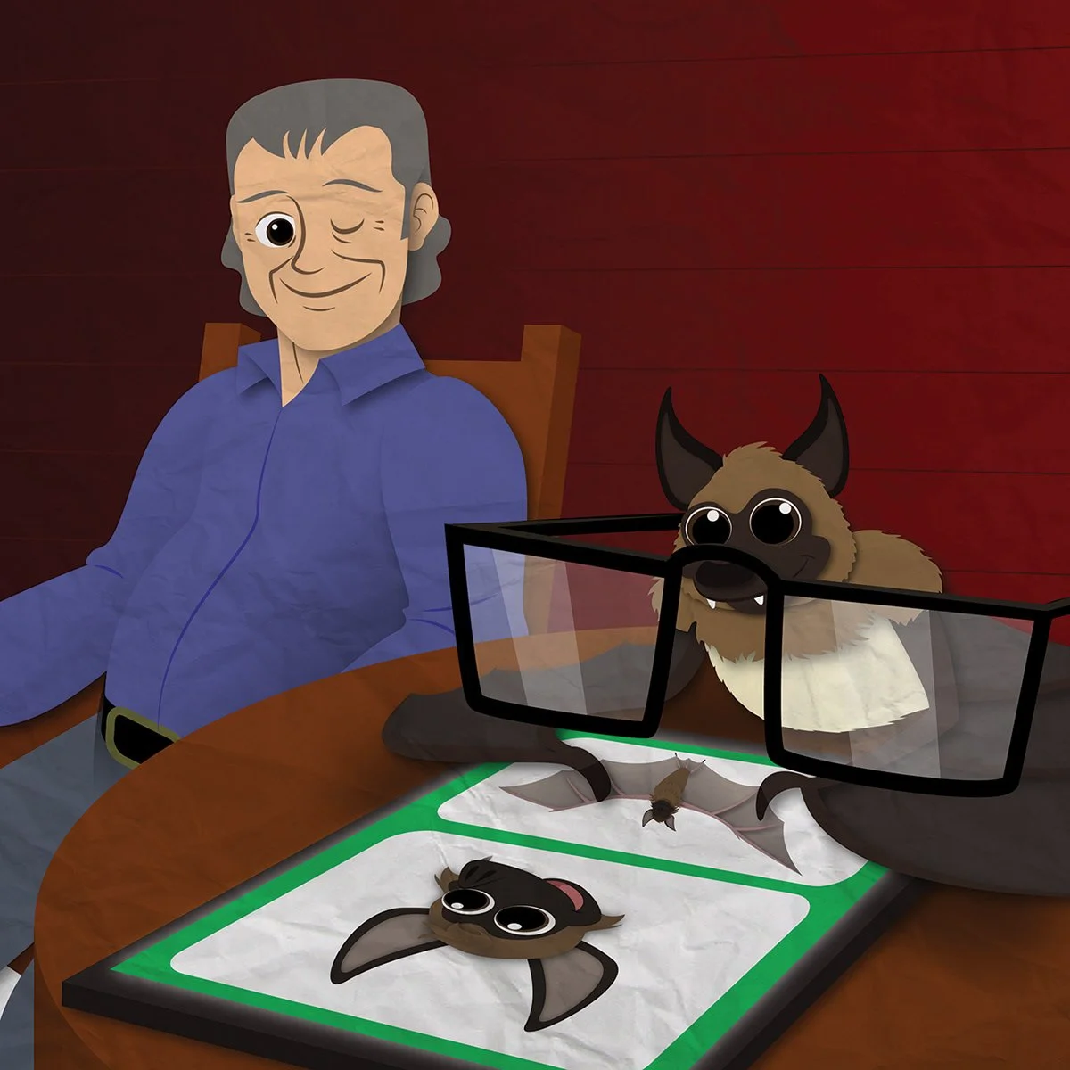 A cartoon man with gray hair wearing a blue shirt sitting at a table with two paper crafts of bats, one large with big glasses and one small without glasses, on a white sheet of paper, all set against a wooden wall background.