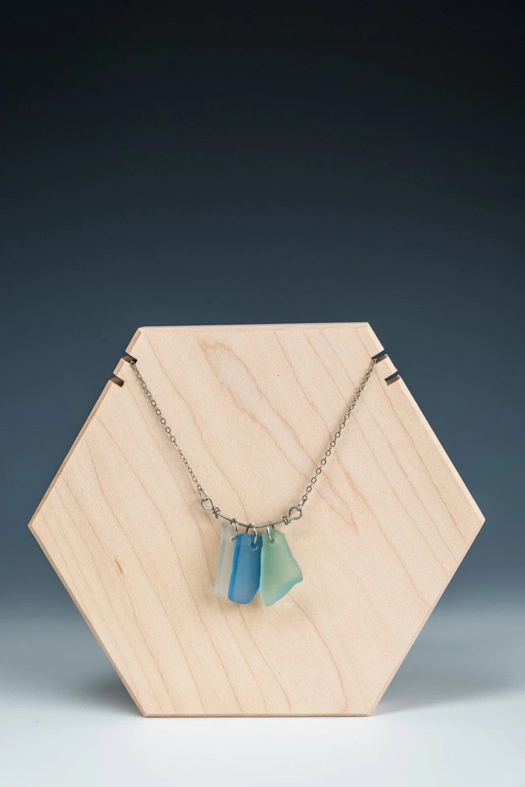 Handmade necklaces featuring unique fragments of reclaimed bottle glass, each piece naturally shaped and polished while retaining its organic edges. The glass varies in color and size, making every necklace a singular, wearable remnant of a larger wo