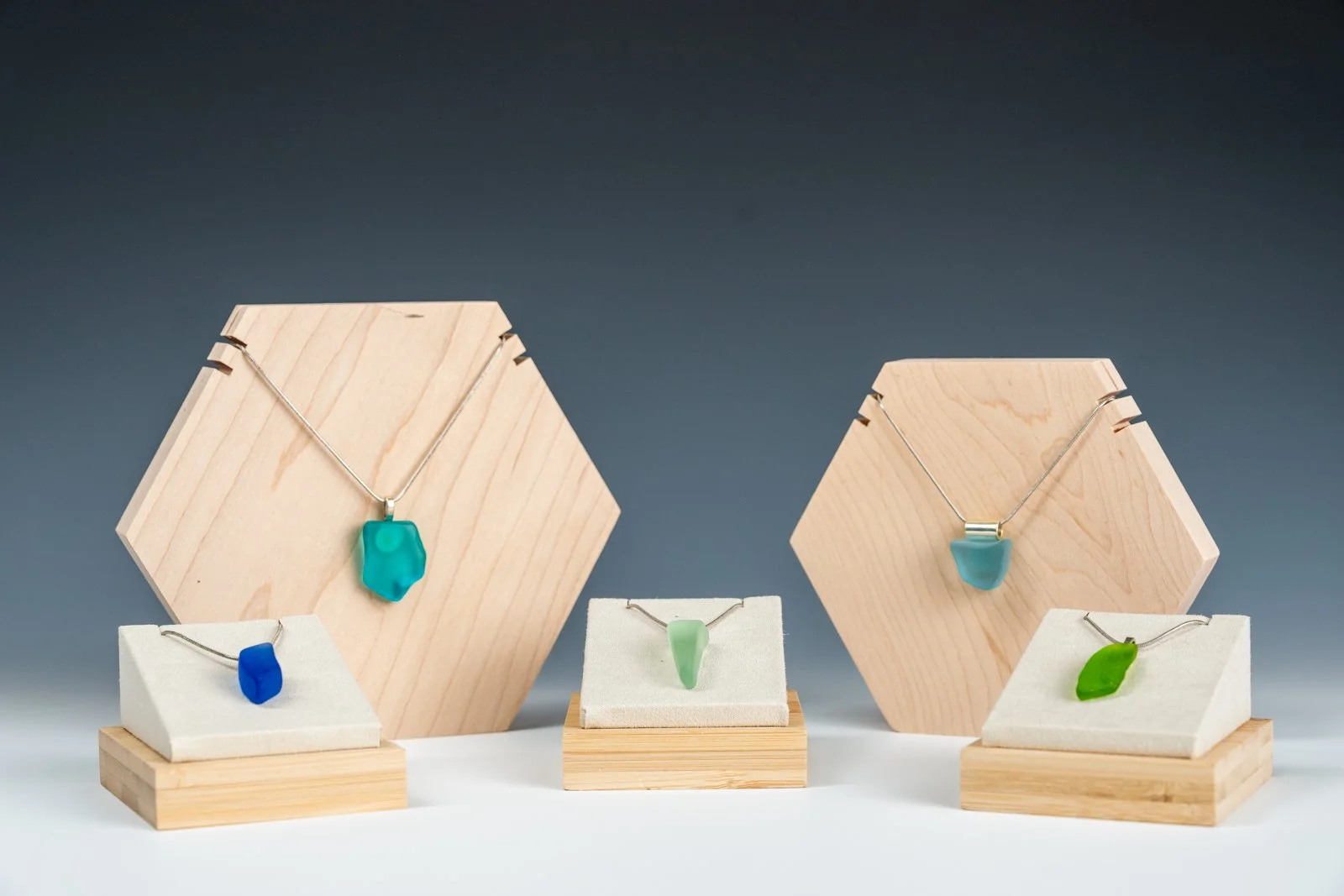 Handmade necklaces featuring unique fragments of reclaimed bottle glass, each piece naturally shaped and polished while retaining its organic edges. The glass varies in color and size, making every necklace a singular, wearable remnant of a larger wo