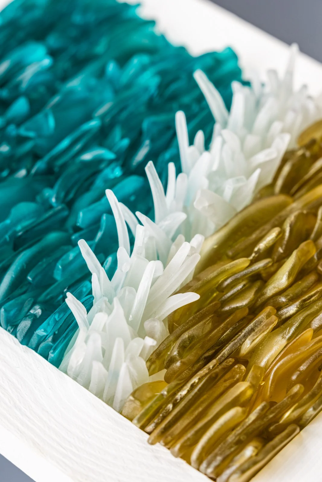 Close-up of colorful fishing lures organized in rows in a box.