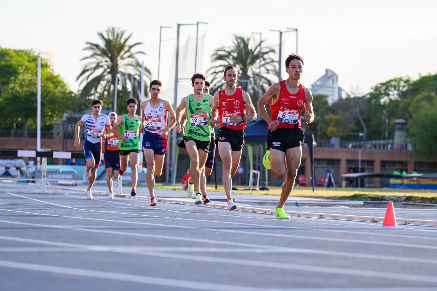 Corredores compitiendo en una pista de atletismo durante una competencia.
