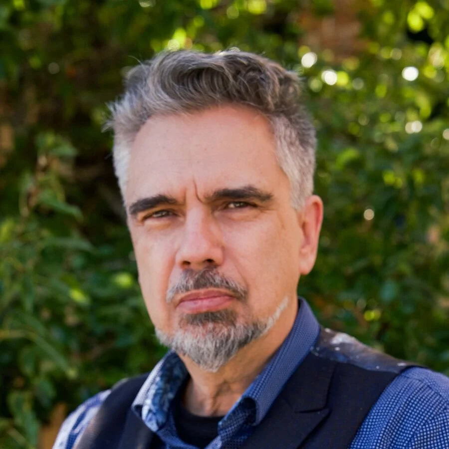 Headshot of Dr. Miguel de La Torre in front of shrubbery outside.
