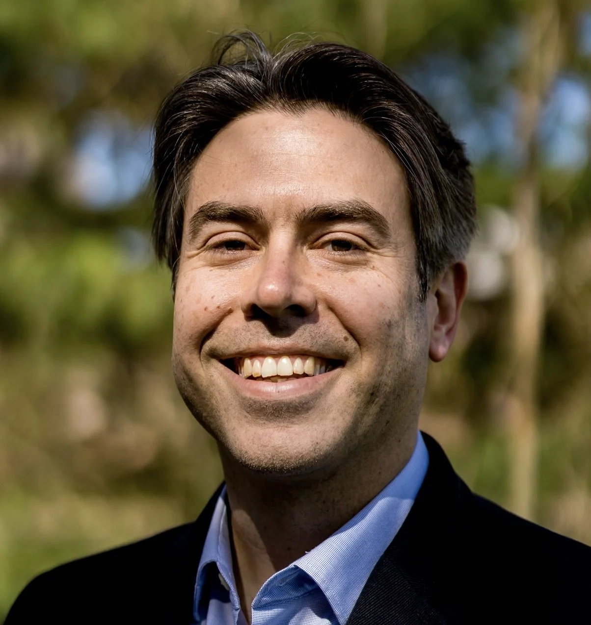 Headshot of Matthew Croasmun in front of wooded background