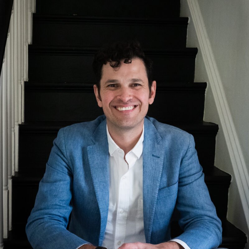 Headshot of Jared Byas sitting on a set of stairs.
