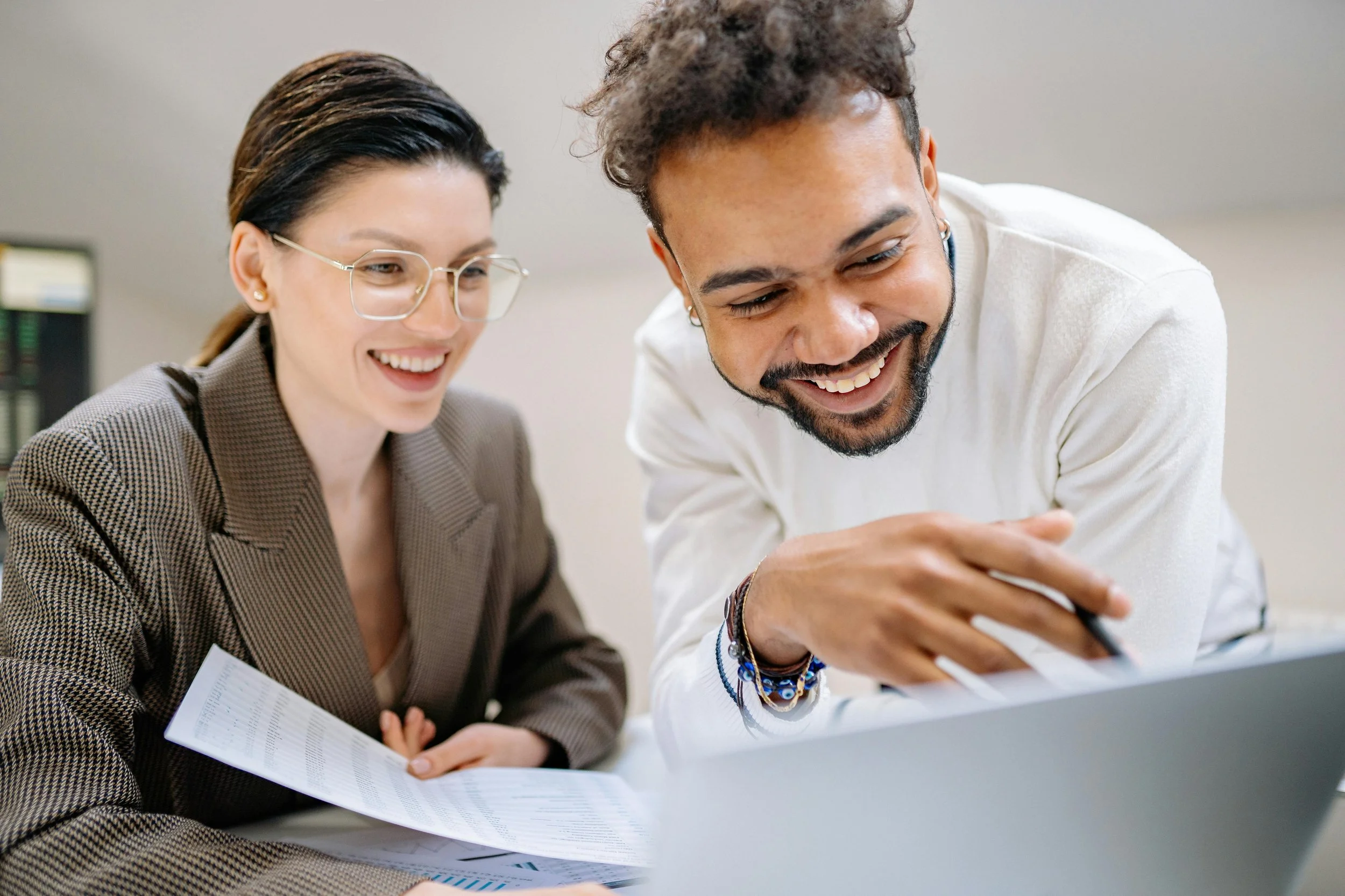 Two people smiling and looking at a computer