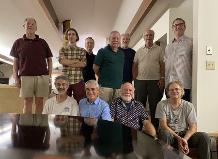 Group of ten people gathered in a living room for a photo.