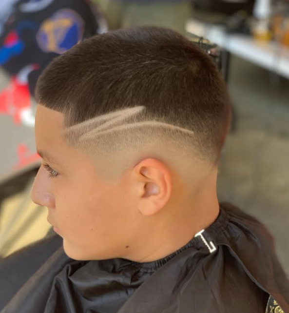 Young man with a short haircut featuring a fade and three shaved lines in the side