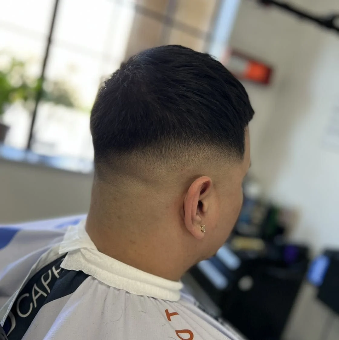 Close-up of a man with a fresh fade haircut in a barbershop.