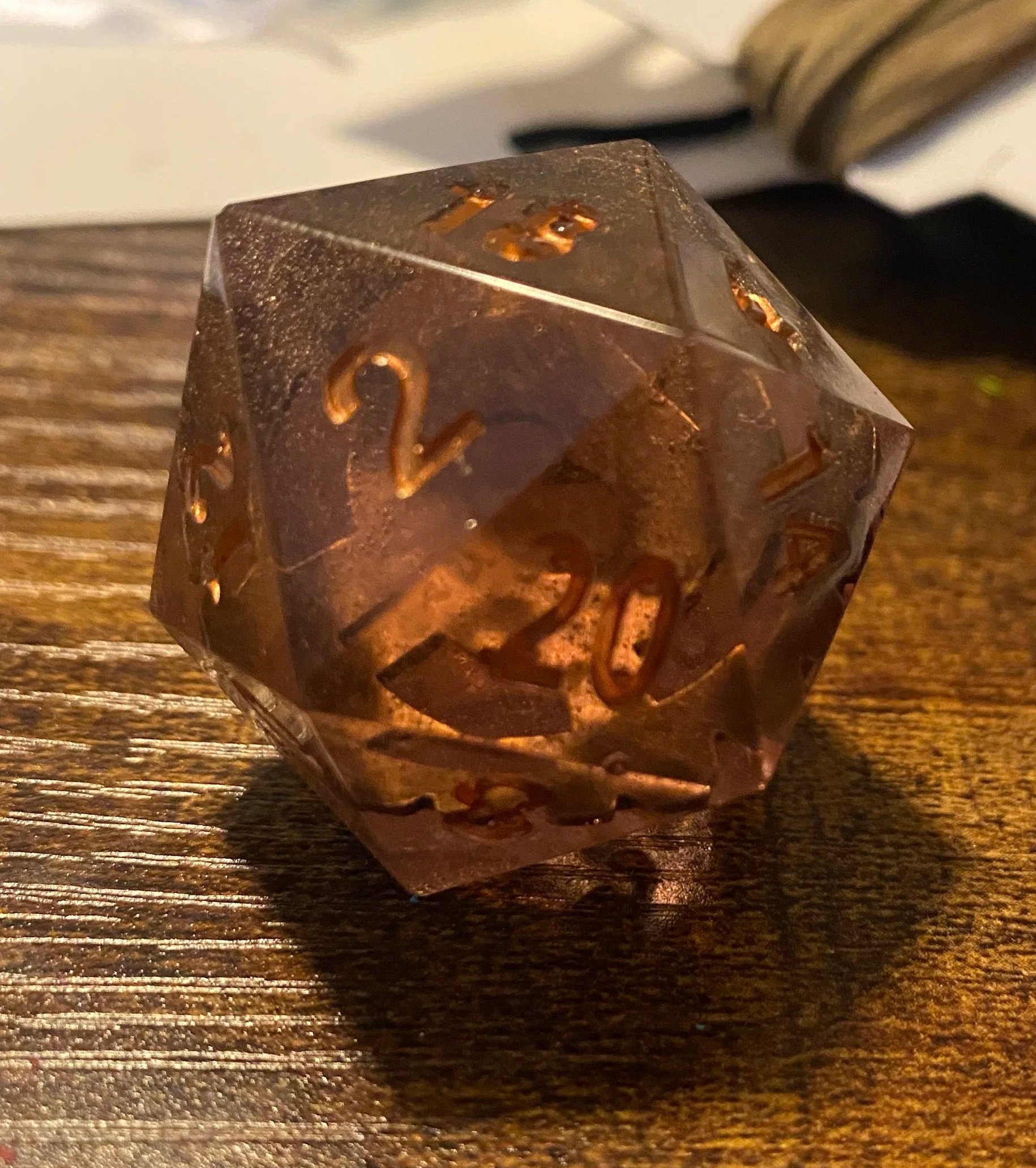 At the end of our first big campaign, I made a set of dice for each of the players that contained a die that referenced all of our characters. This was for our artificer and featured a gear in amber-tinted resin. 