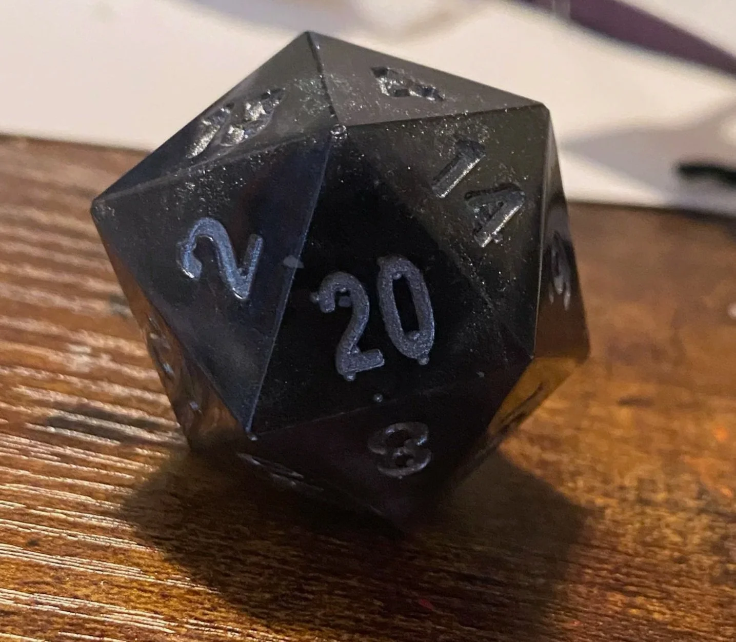 At the end of our first big campaign, I made a set of dice for each of the players that contained a die that referenced all of our characters. This was for our rogue who went by "The Shadow." The resin wasn't quite opaque and featured silver glitter 